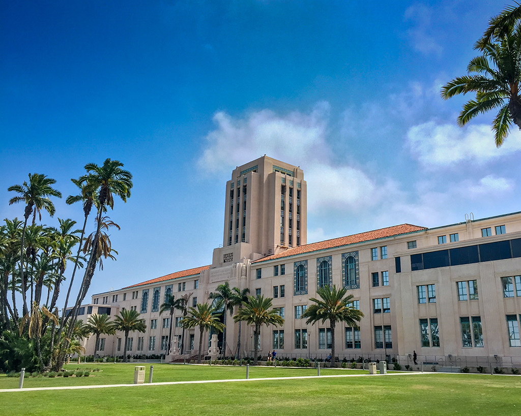 County Administration Center building with palm trees in the foreground and a blue sky behind the building.